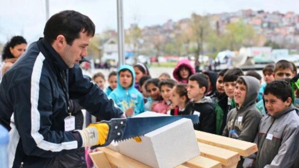 Man holding a saw, showing to youth stakeholders the outcomes of the project through insightful demonstrations